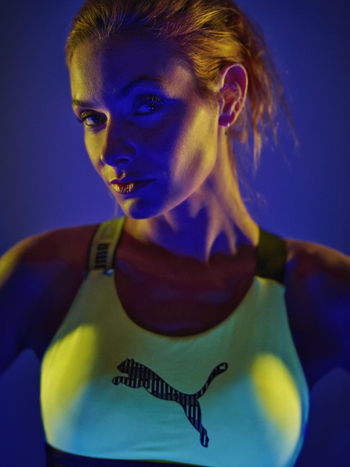 Portrait sportliche Frau im farbigen LED Licht
