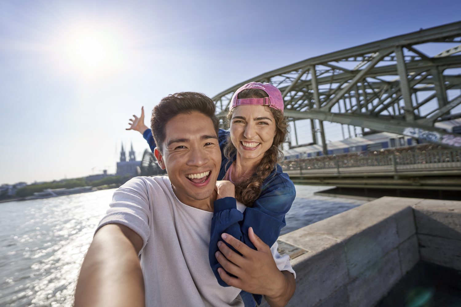 Junges Pärchen fotografiert ein Selfie vom Kölner Dom und Rhein in Köln